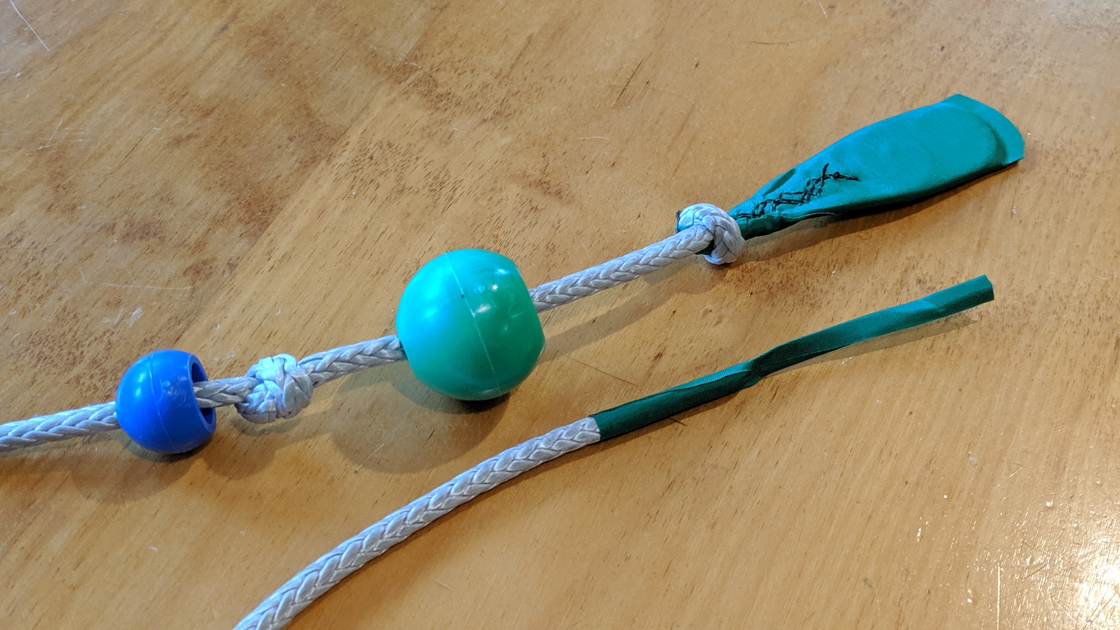 Grip end of the trim line with balls offset to show knots (above) and thread end (below)